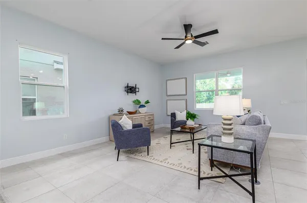 a living room with furniture kitchen view and a window