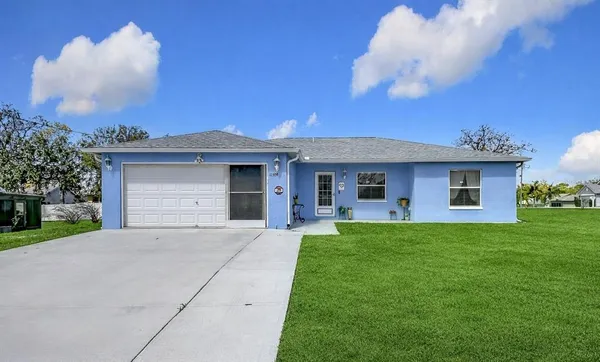 a front view of a house with a garden and yard