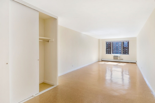 97-11 Horace Harding Expressway, Unit 18F Queens, NY 11368 - Photo 12 of 13 a view of an empty room with a window and wooden floor