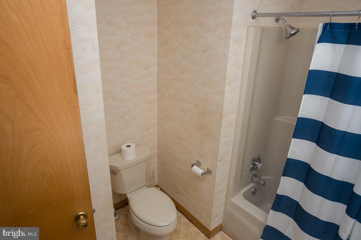 13148 Fleetwood Pond Road Seaford, DE 19973 - Photo 13 of 25 a white toilet sitting next to a shower curtain