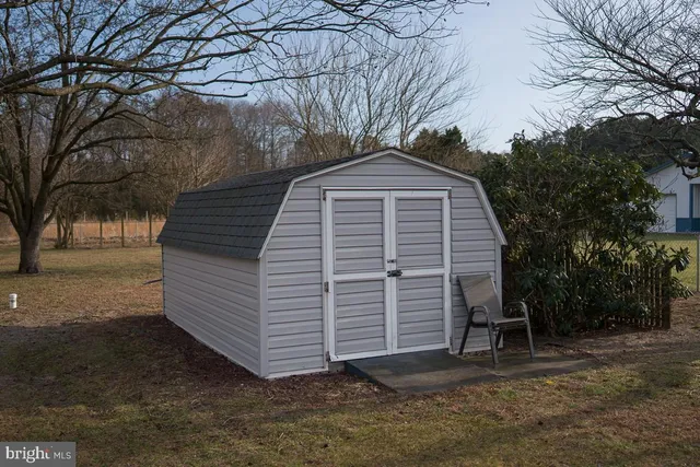 a view of a house with a large tree and a yard
