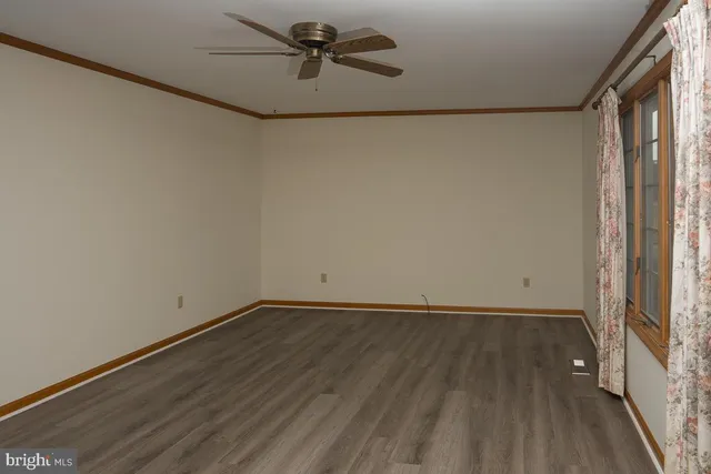 a view of small space with wooden floor and a window