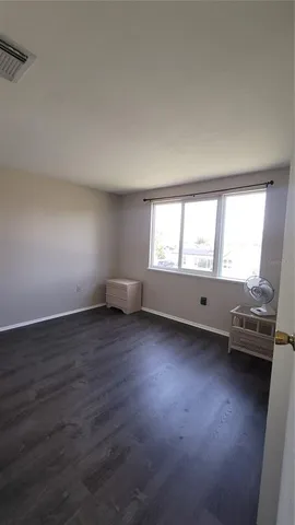 a view of a room with wooden floor and windows