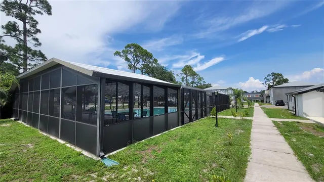a view of a backyard with potted plants and large trees
