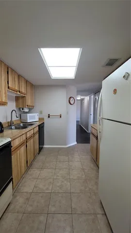 a kitchen with a sink a refrigerator and cabinets