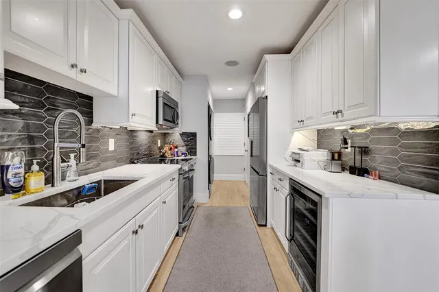a kitchen with granite countertop a sink stove and refrigerator