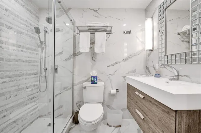 a bathroom with a granite countertop toilet sink and a mirror