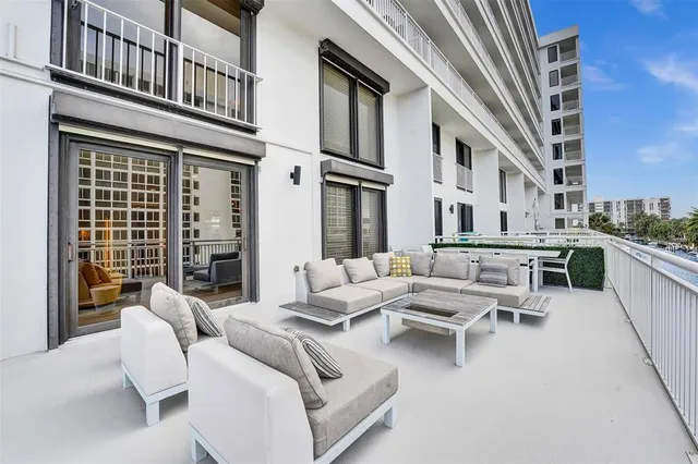 a view of a patio with couches table and chairs and potted plants