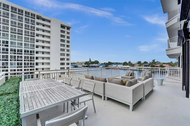 a roof deck with couches and potted plants