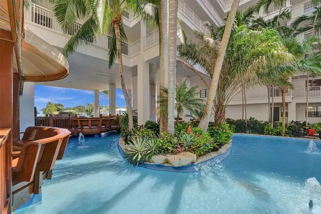 a view of a swimming pool with lawn chairs and plants