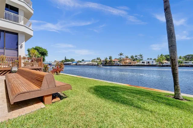 a view of an ocean with boats and trees in the background