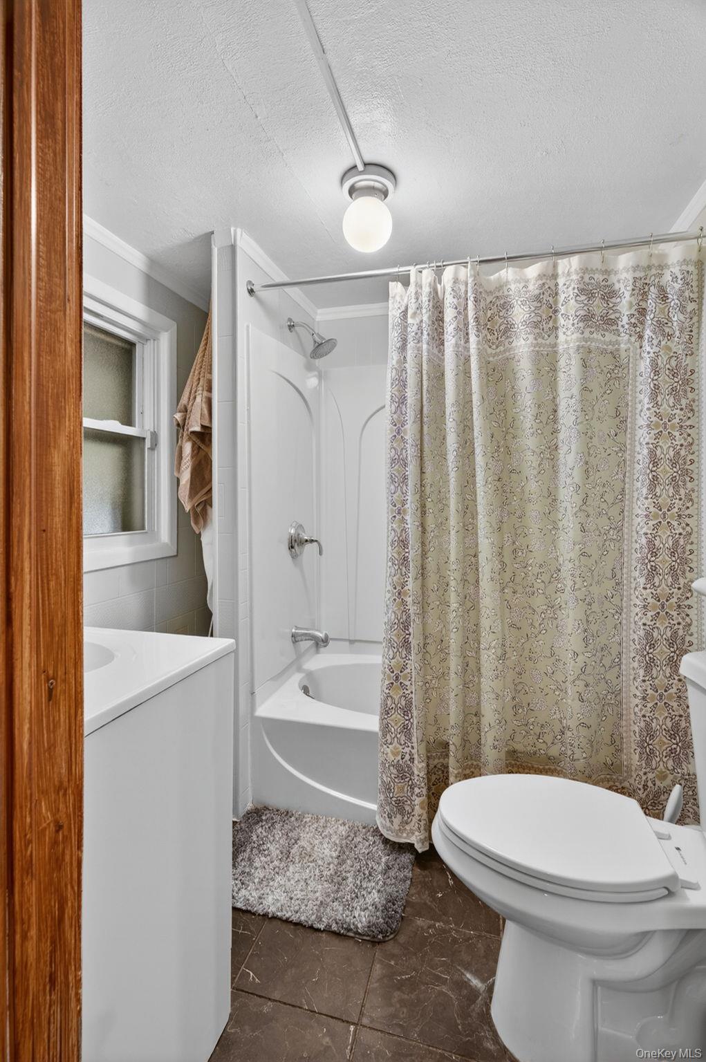 7 Walnut Street Poughkeepsie, NY 12601 - Photo 13 of 30 The first-floor bathroom is thoughtfully designed for both comfort and convenience, featuring a full tub and shower combination that is perfect for daily routines.