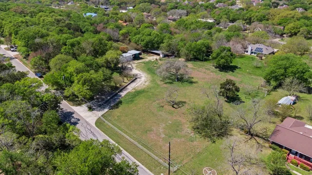 an aerial view of residential house with outdoor space and trees all around