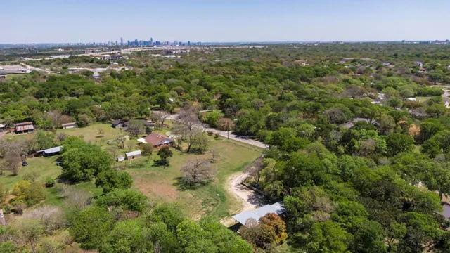 an aerial view of residential houses with outdoor space and trees