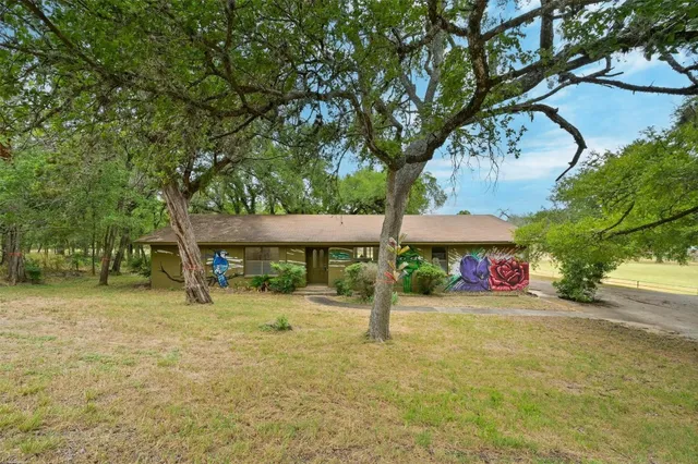 a view of a house with a tree and a yard