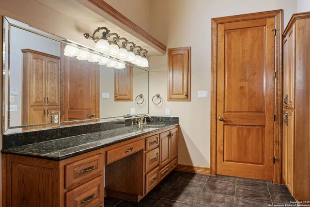 a bathroom with a granite countertop sink and a mirror
