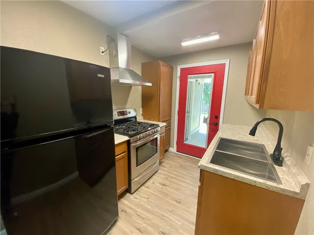 a kitchen with granite countertop a refrigerator and a stove