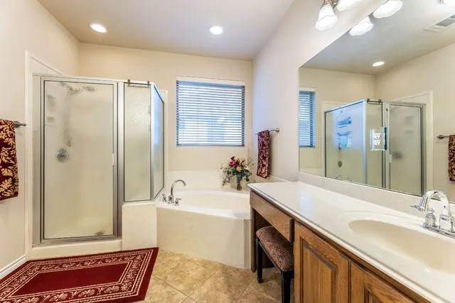 a spacious bathroom with a tub sink and mirror