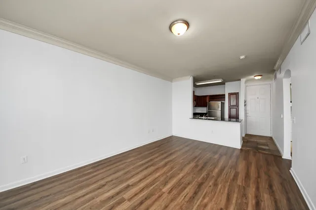 a view of a big room with wooden floor and a kitchen