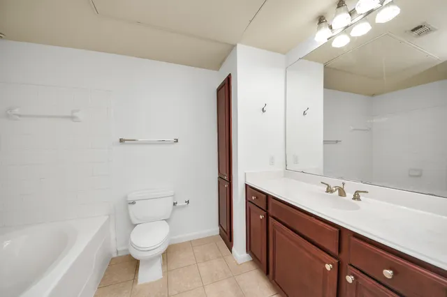 a bathroom with a sink a toilet a large mirror and shower