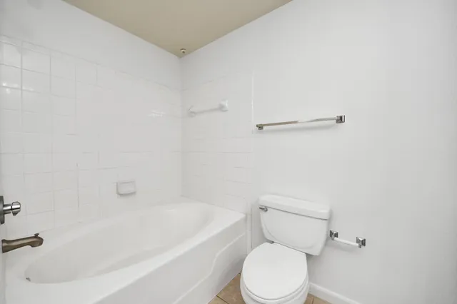 a white toilet sitting next to a bath tub