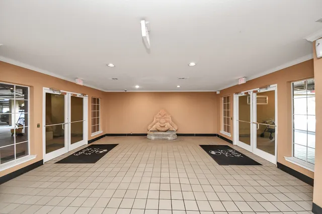 a view of an empty room with wooden floor and windows