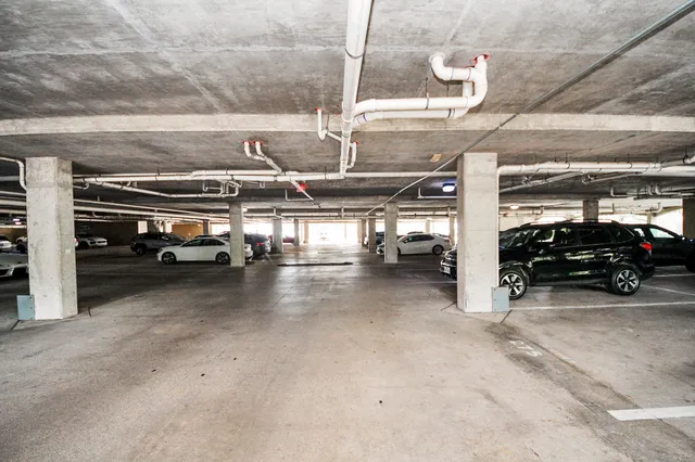 a view of parking garage with cars parked