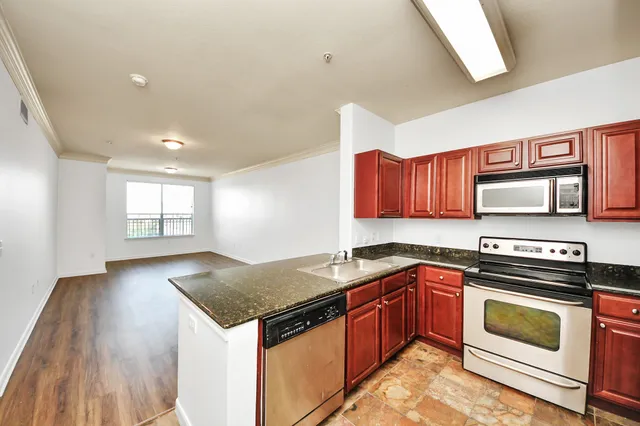 a kitchen with granite countertop a sink stove and cabinets