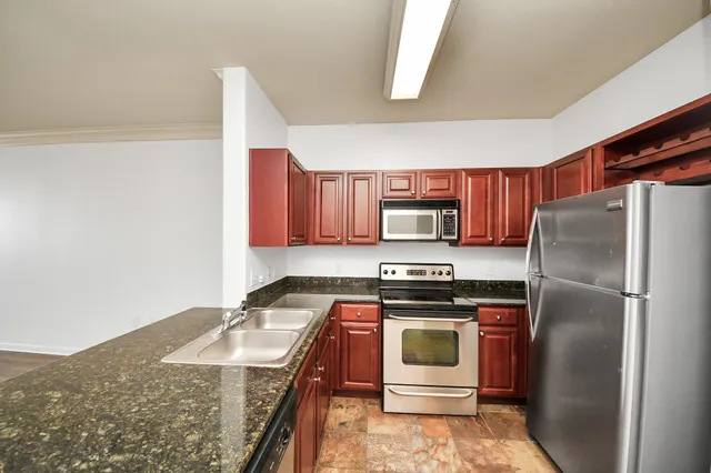 a kitchen with stainless steel appliances granite countertop a refrigerator and a stove