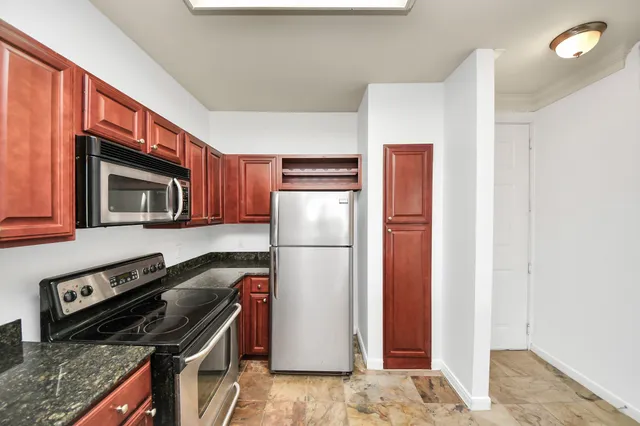 a kitchen with stainless steel appliances granite countertop a refrigerator and a stove