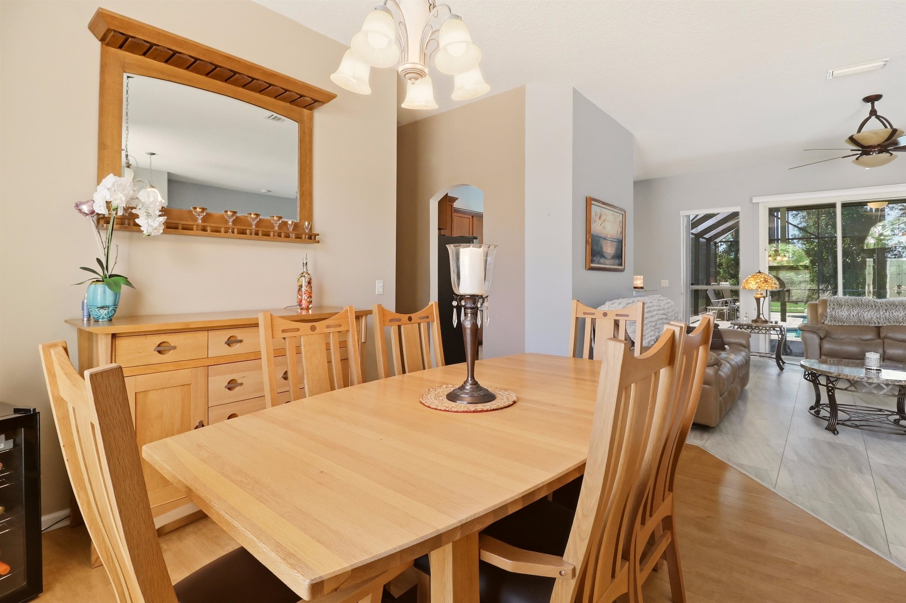 273 Whisper Ridge Drive St. Augustine, FL 32092 - Photo 16 of 44 Dining space featuring arched walkways, a chandelier, and a ceiling fan