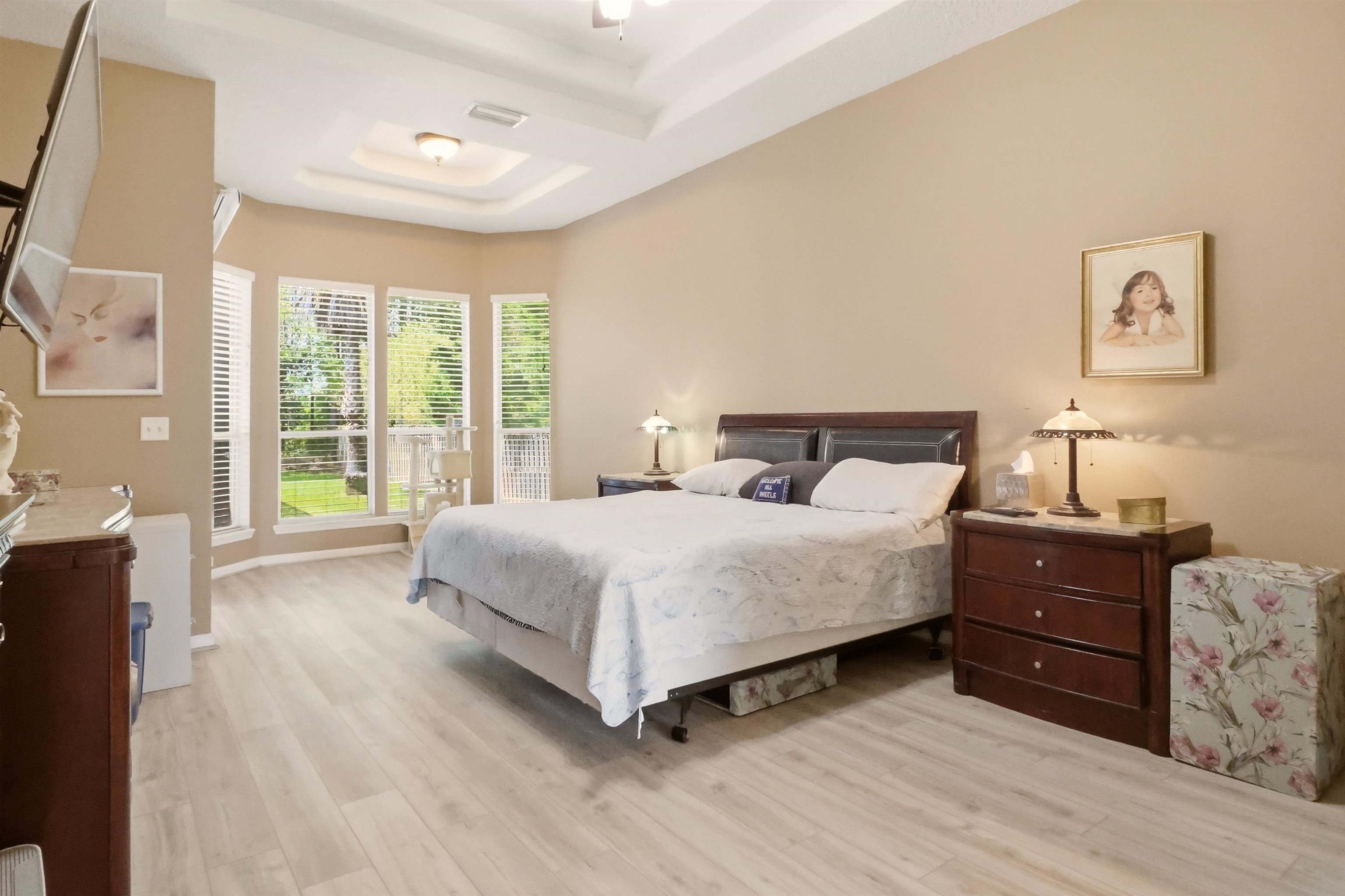 273 Whisper Ridge Drive St. Augustine, FL 32092 - Photo 23 of 44 Bedroom with a tray ceiling, sitting area, access to outside, and light LVP flooring