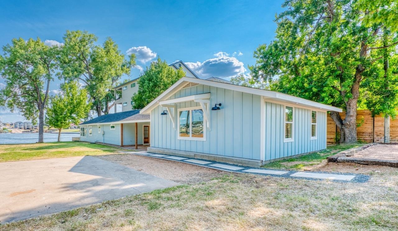 a view of a house with a yard and large tree