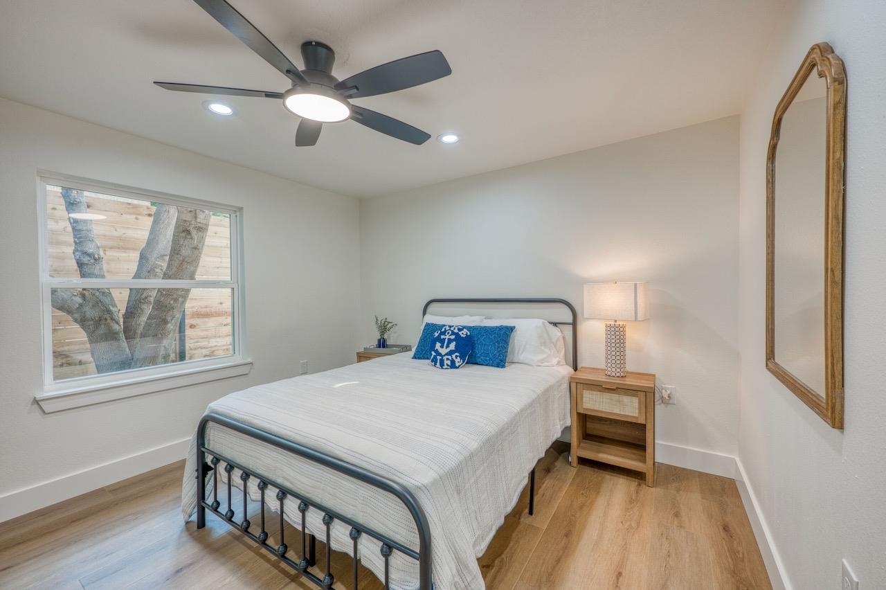 569 Ellen Williams Loop Kingsland, TX 78639 - Photo 19 of 29 a bedroom with a bed and a large window with wooden floor