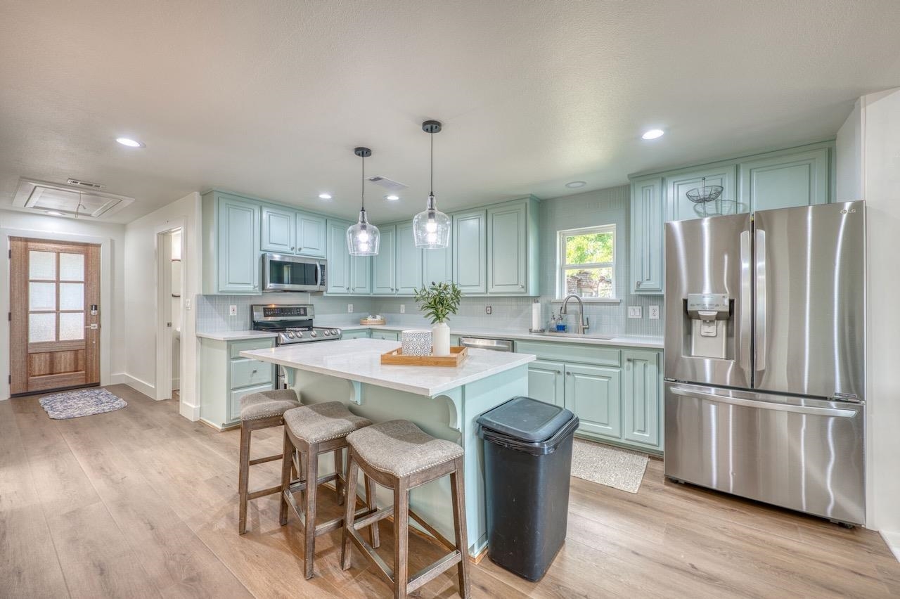 569 Ellen Williams Loop Kingsland, TX 78639 - Photo 6 of 29 a kitchen with kitchen island wooden cabinets and stainless steel appliances