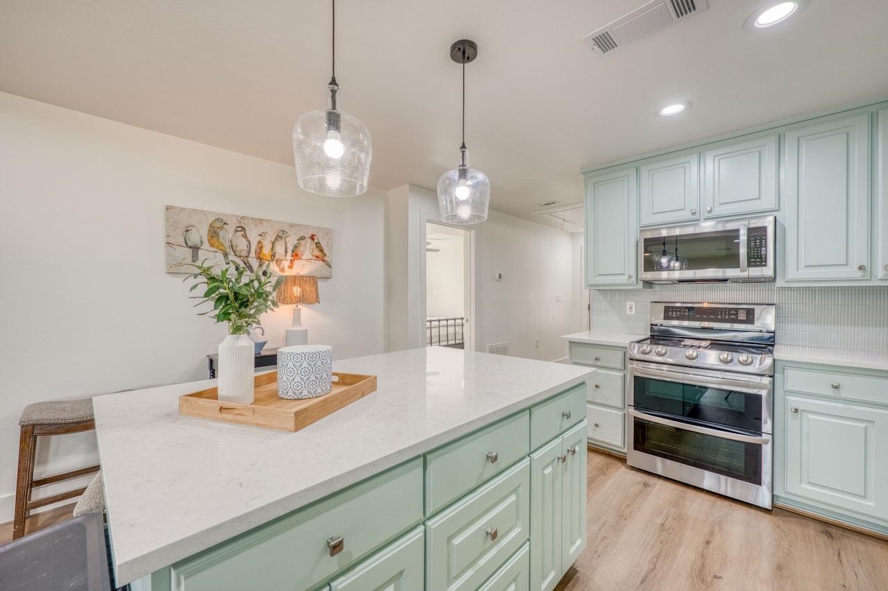 569 Ellen Williams Loop Kingsland, TX 78639 - Photo 7 of 29 a kitchen with kitchen island white cabinets and stainless steel appliances