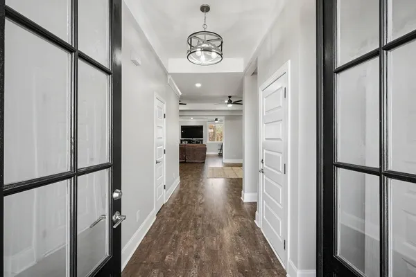 a view of a hallway with wooden floor and staircase