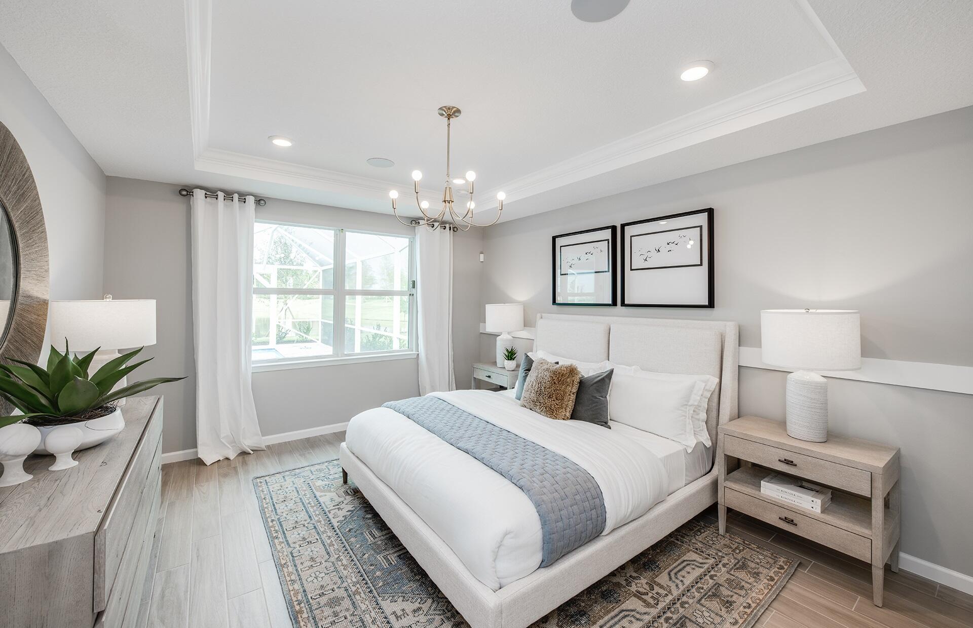 10461 Southwest Highpointe Drive, Unit WHITESTONE 258 Stuart, FL 34997 - Photo 15 of 32 a bedroom with a large bed and a chandelier