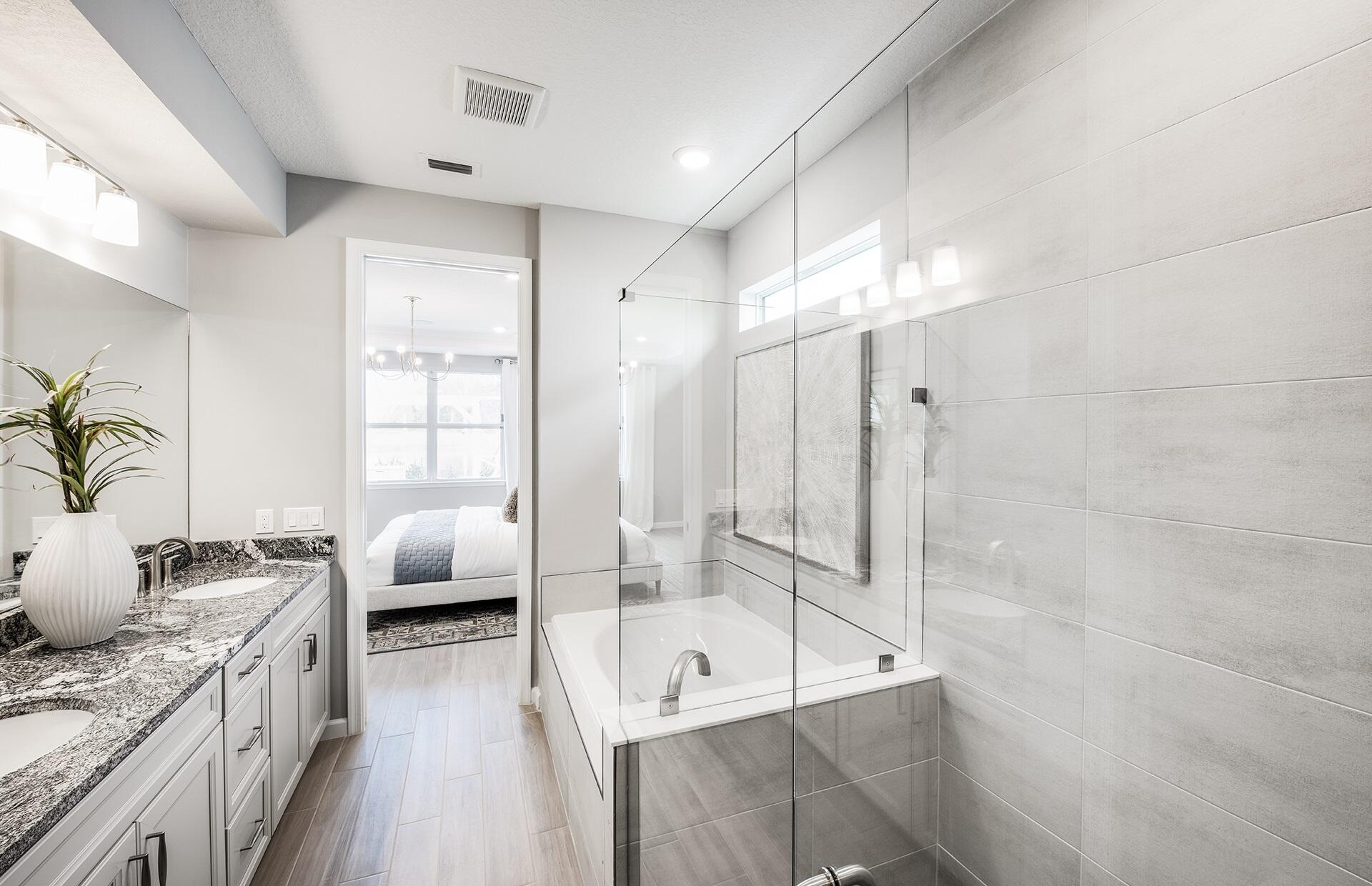 10461 Southwest Highpointe Drive, Unit WHITESTONE 258 Stuart, FL 34997 - Photo 16 of 32 a spacious bathroom with a granite countertop tub sink and glass door