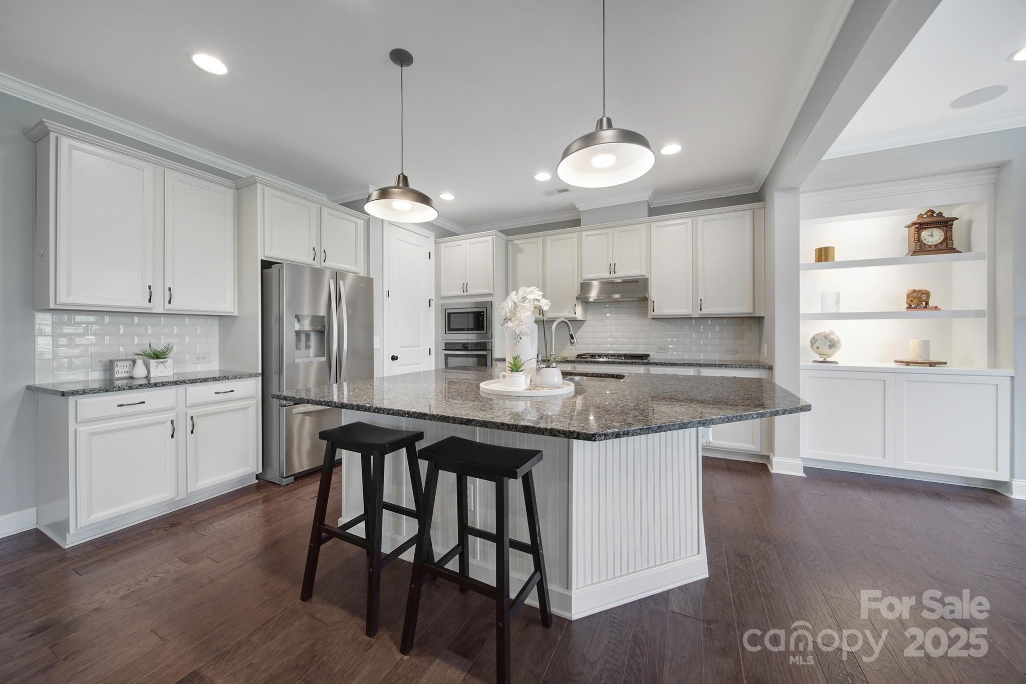 1001 Emory Lane Fort Mill, SC 29708 - Photo 4 of 45 a kitchen with stainless steel appliances granite countertop a sink a stove a refrigerator and island with wooden floor