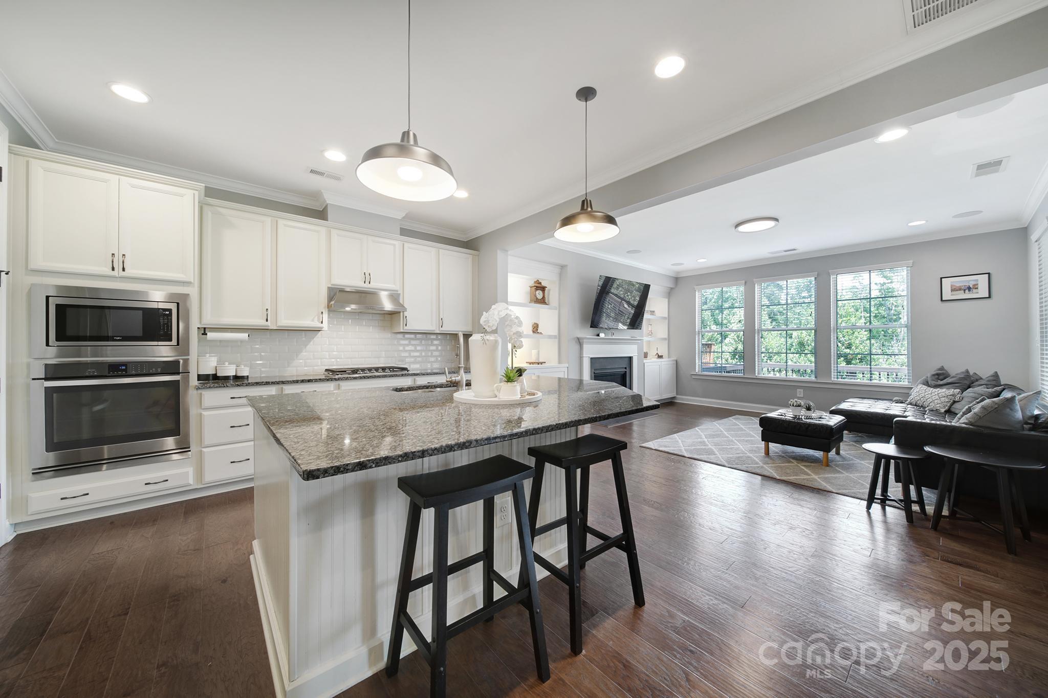 1001 Emory Lane Fort Mill, SC 29708 - Photo 5 of 45 a kitchen with stainless steel appliances granite countertop a stove a refrigerator a kitchen island a dining table and chairs with wooden floor
