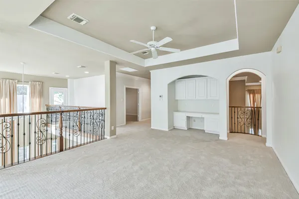 an empty room with windows and ceiling fan