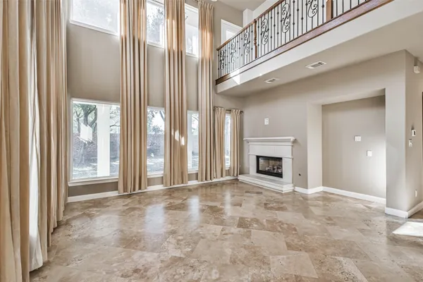 a view of an empty room with a fireplace and a window