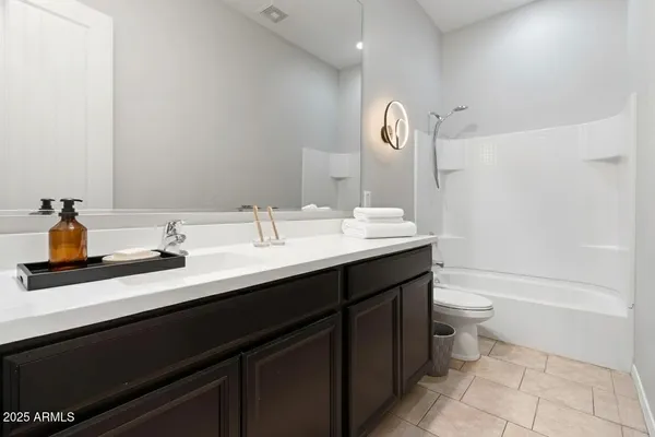 a bathroom with a double vanity sink a toilet and a bathtub