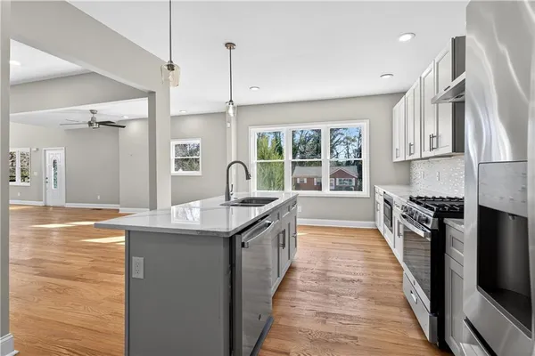 a kitchen with stainless steel appliances granite countertop a sink and a wooden floors
