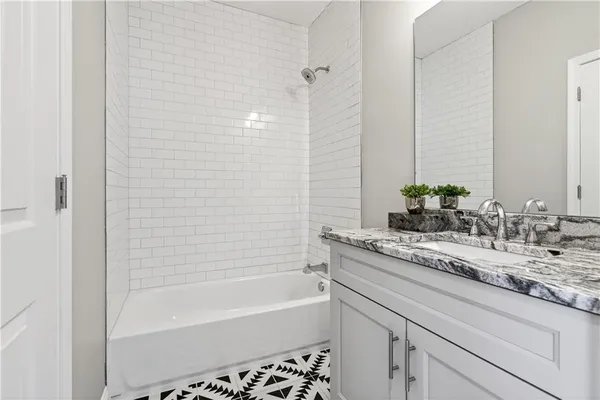 a bathroom with a granite countertop sink and a bathtub