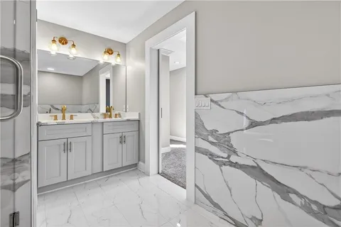 a spacious bathroom with a double vanity sink a mirror and a shower