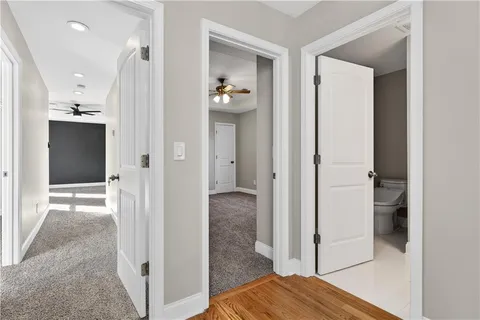 a view of a hallway with wooden floor and staircase
