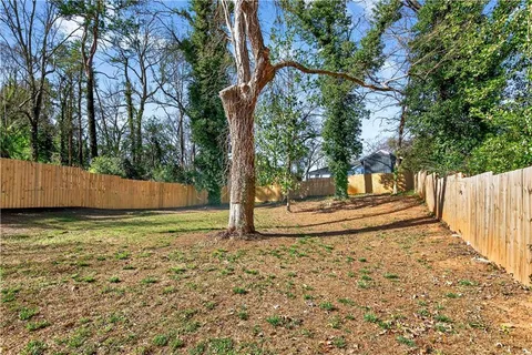 a view of a yard with wooden fence