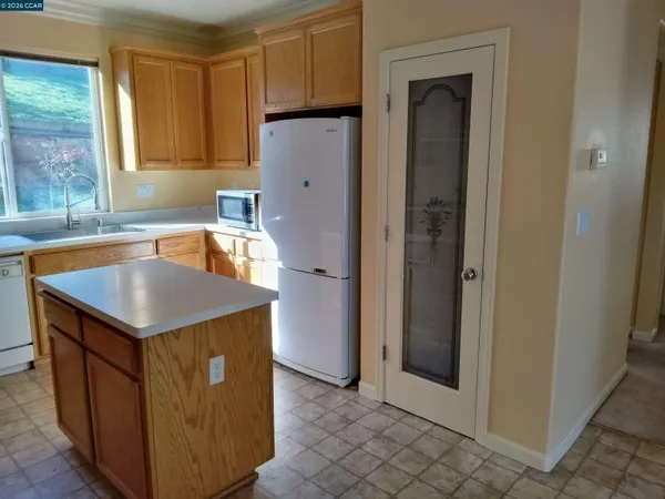 a kitchen with a sink a refrigerator and window